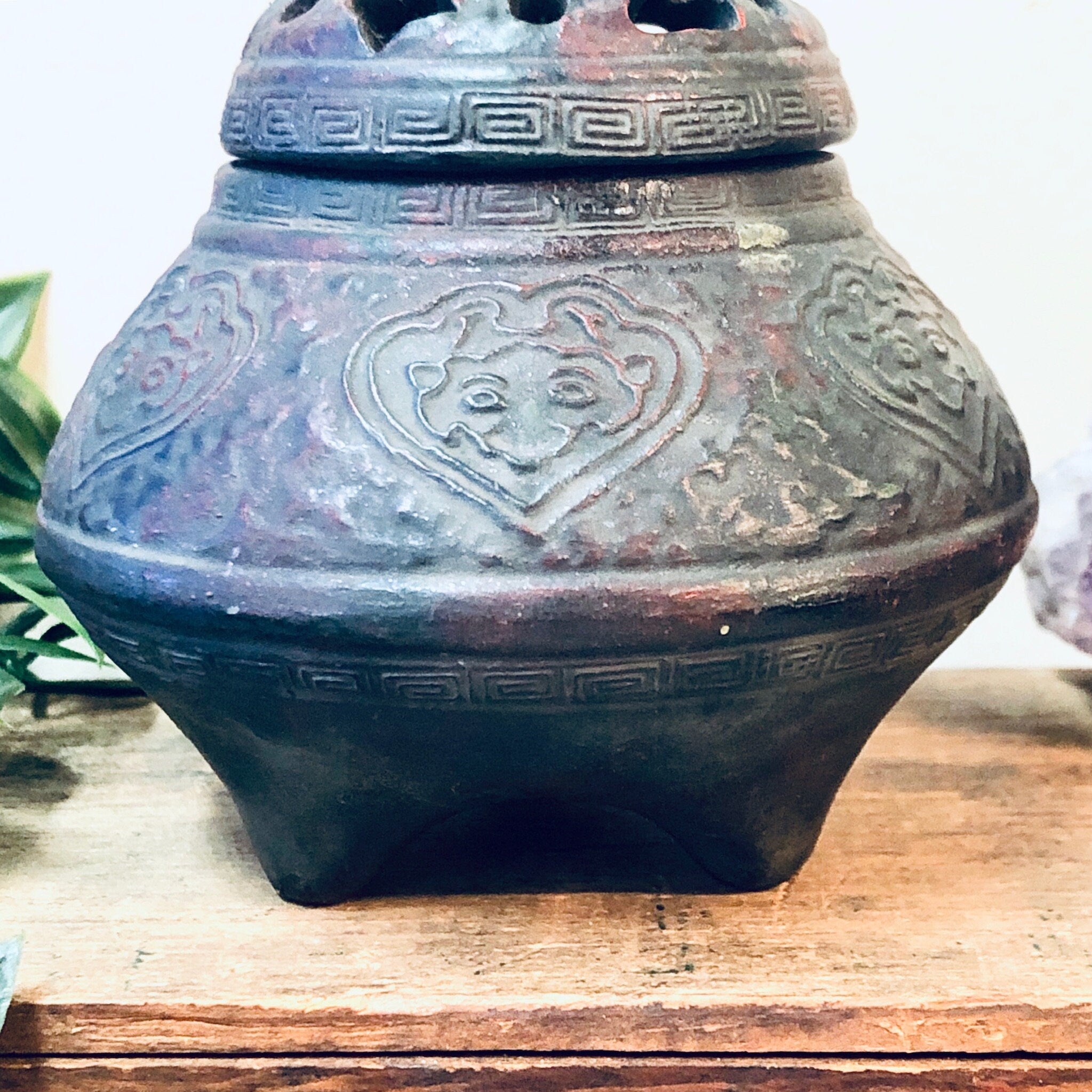 Ornate antique incense burner with intricate floral carvings on a weathered metal surface, featuring a decorative lidded design, perfect as a unique vintage home decor piece or housewarming gift.