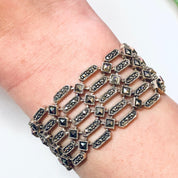 Alt text: Vintage sterling silver marcasite link bracelet on a person's wrist, featuring a geometric design with multiple rows of rectangular silver links adorned with small marcasite stones, creating an elegant statement jewelry piece suitable as a Valentine's Day gift.