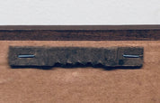 Rusty metal sign mounted on weathered brown paper, likely an antique or vintage brewery advertisement or beer brand logo.