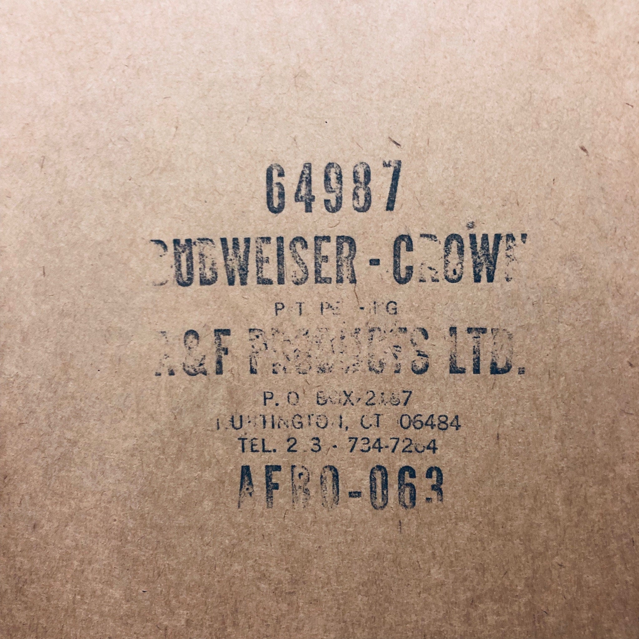 Vintage Budweiser Crown cork-lined beer bottle cap sign on weathered brown paper background