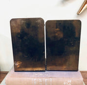 Pair of vintage brass bookends featuring sundial design with Roman numerals, ideal for library decor or as a unique home accent on bookshelves.