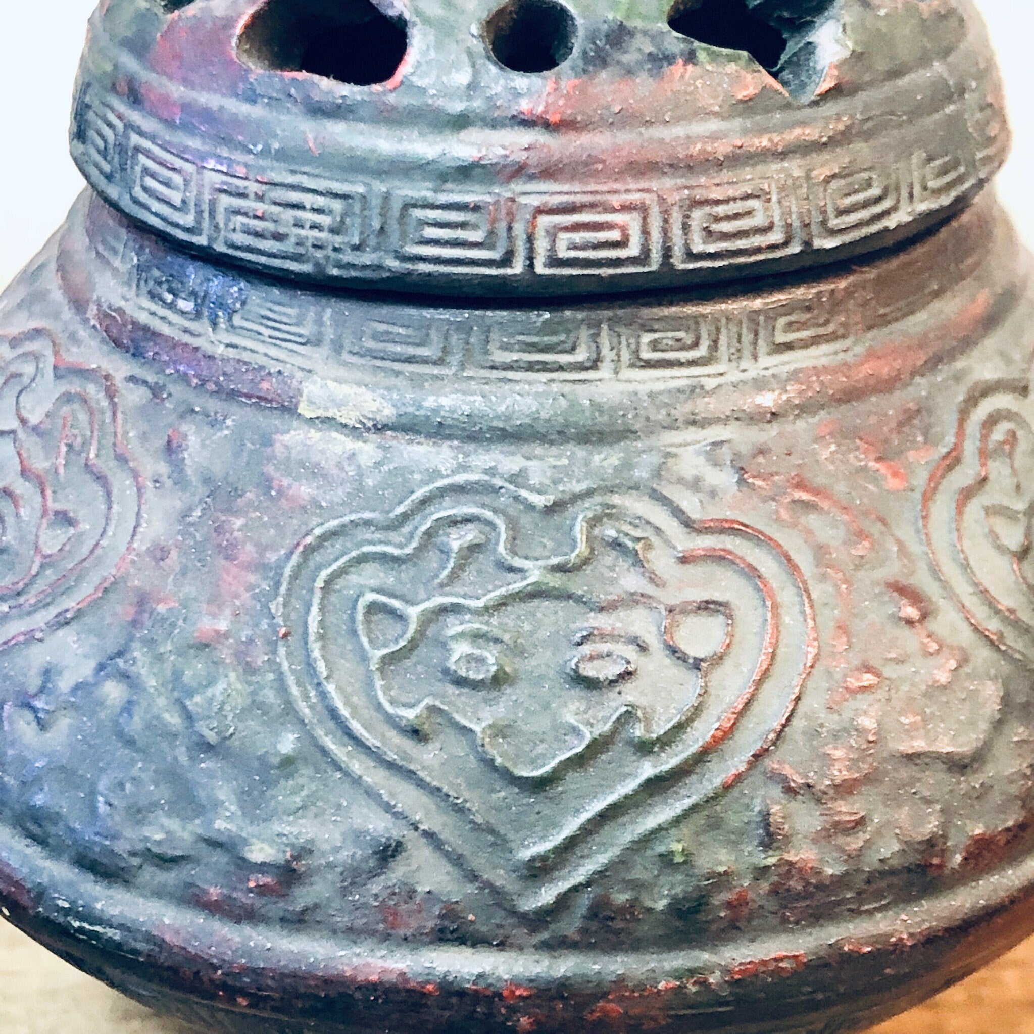 Vintage incense burner with ornate floral design featuring a heart-shaped cutout, textured patina finish, and lidded container for unique home decor or housewarming gift.