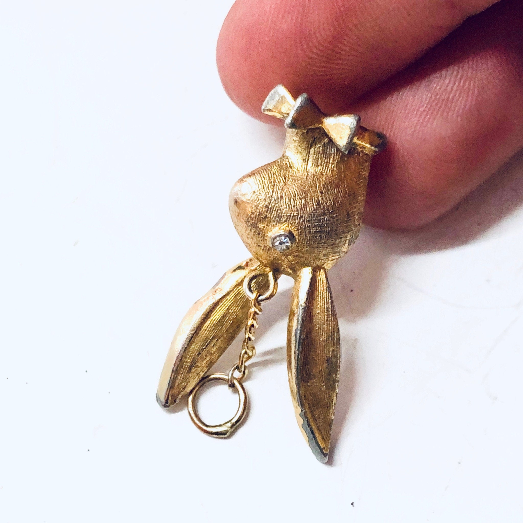 Vintage gold-toned playboy bunny rabbit pendant charm necklace held in fingers