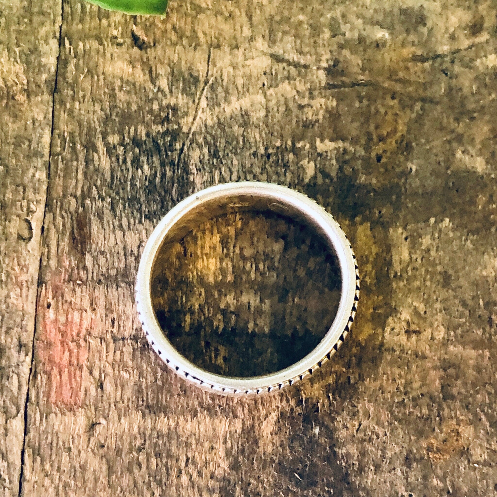 Vintage silver spinner meditation ring on weathered wooden surface