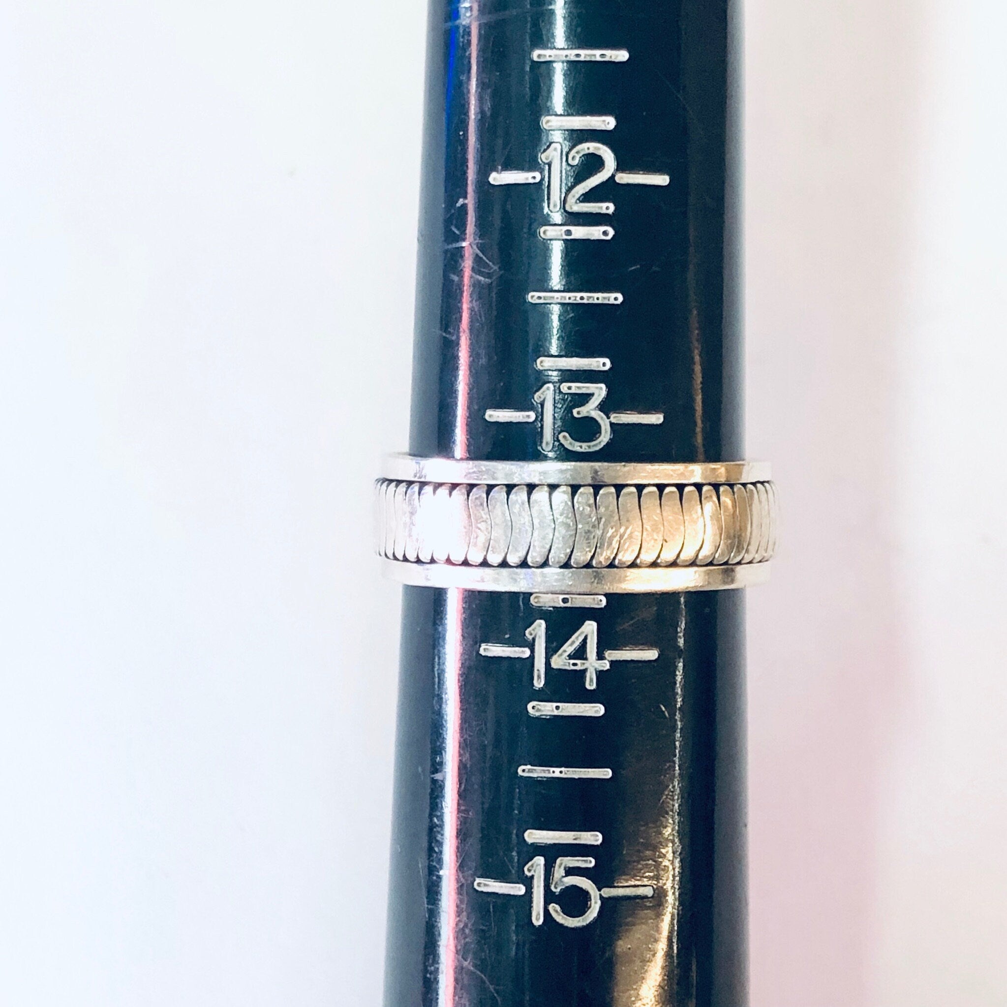 Vintage silver spinner meditation ring showing numbered markings on the band, against a white background.