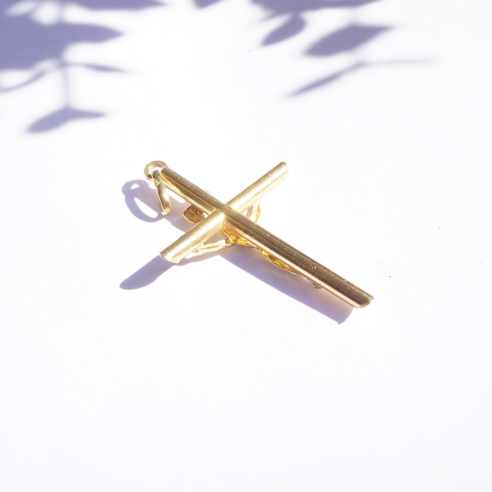 Vintage 14K yellow gold INRI crucifix pendant, an Orthodox cross pendant made in Italy, displayed on a white background with purple shadows.