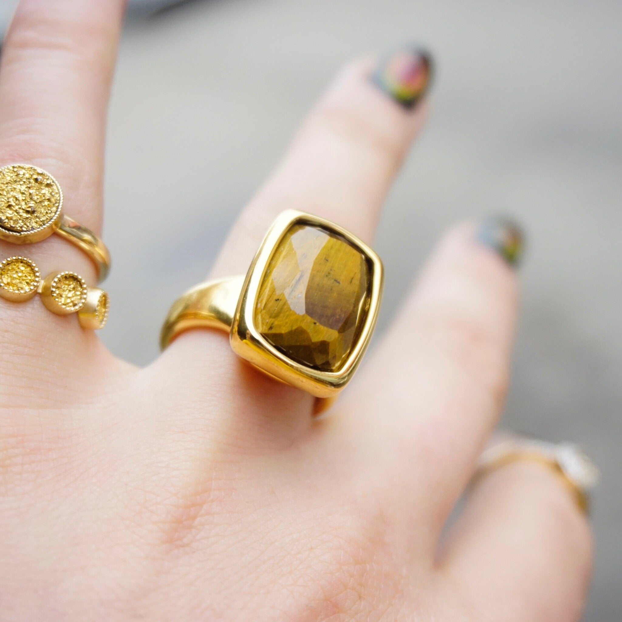 14K gold vintage-style tiger's eye ring with rectangular cut stone set in gold on a hand, gold coin accents, made in Italy by Milor using gold over resin technique.