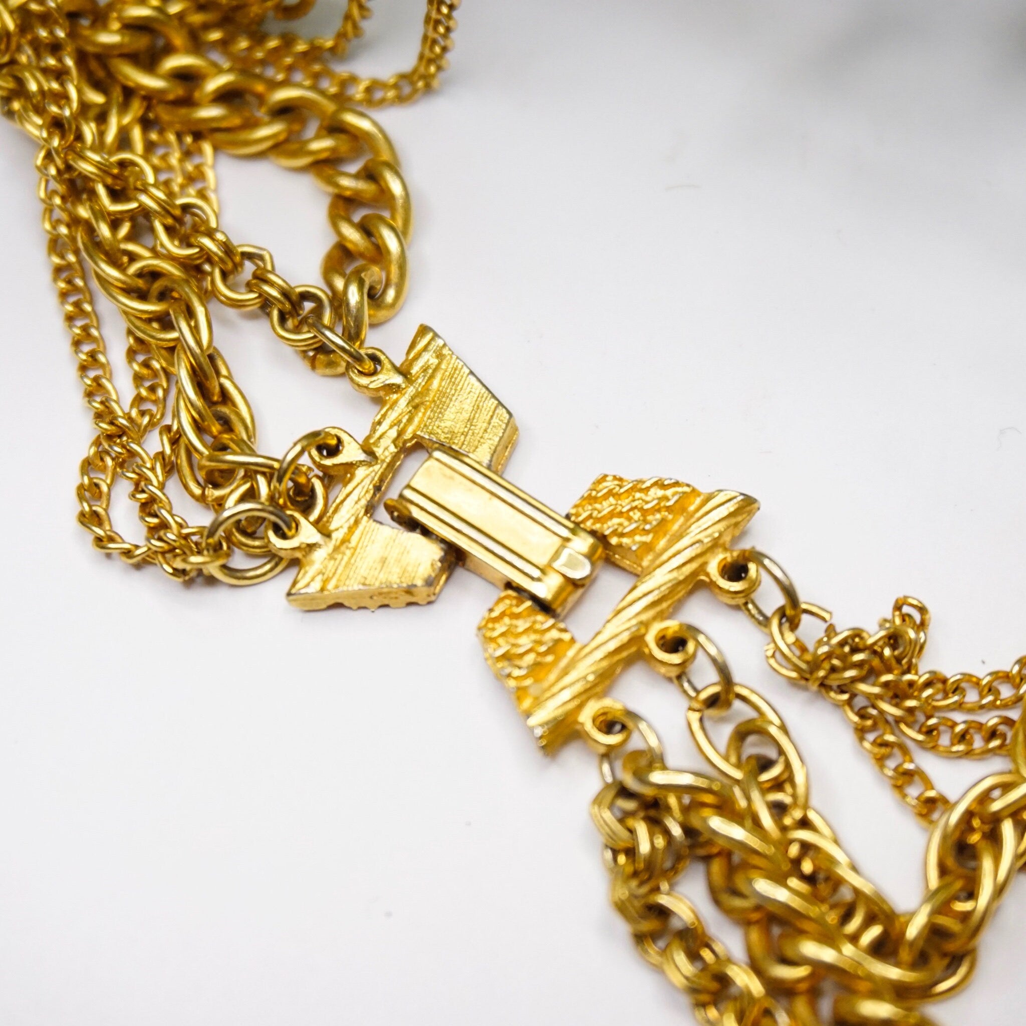 Vintage gold tone layered chain necklace with multiple strands and gold pendants