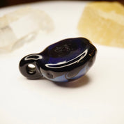 Retro glass pendant with abstract blue and black swirl design, featuring light fractal patterns. Artistic, modernist jewelry piece.