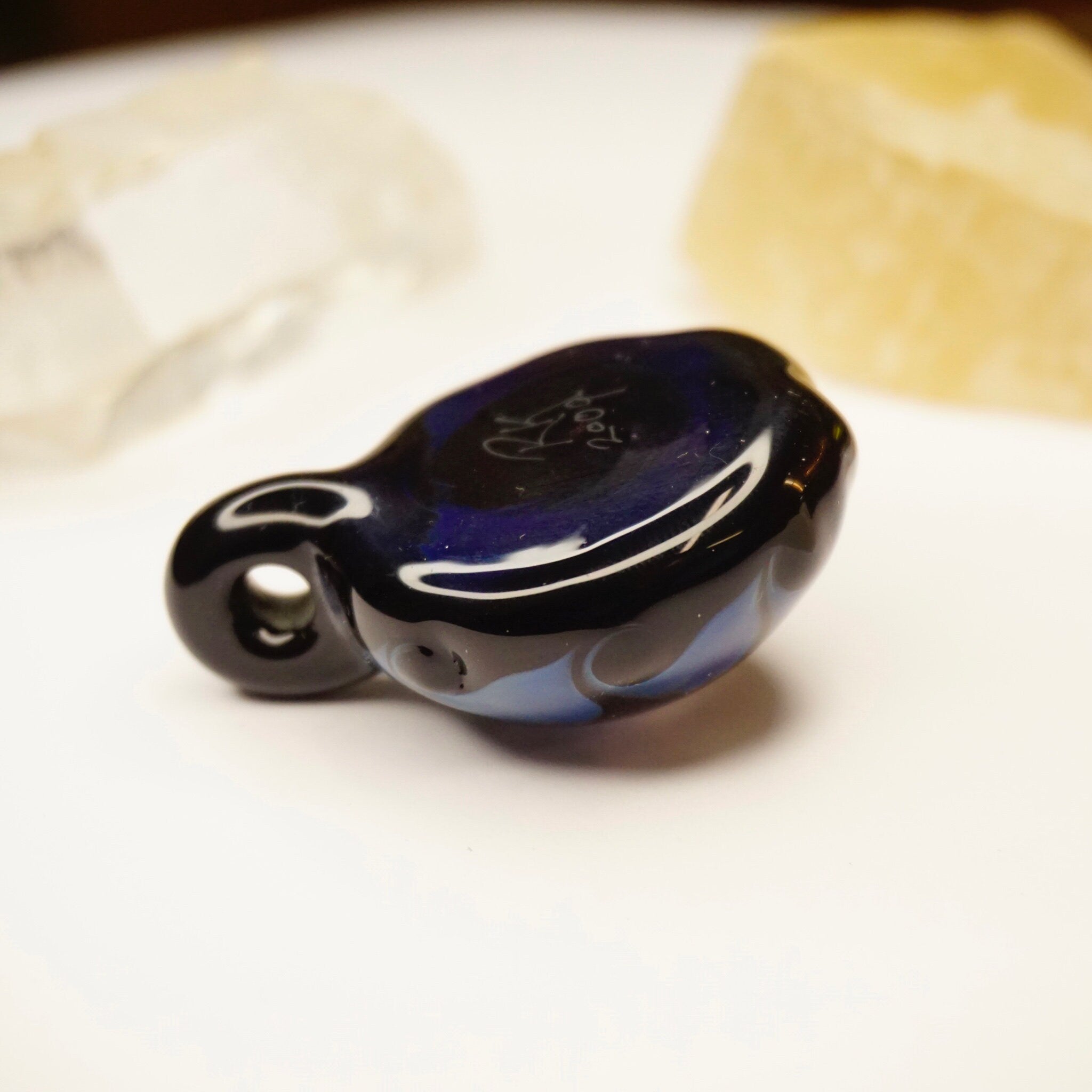 Retro glass pendant with abstract blue and black swirl design, featuring light fractal patterns. Artistic, modernist jewelry piece.