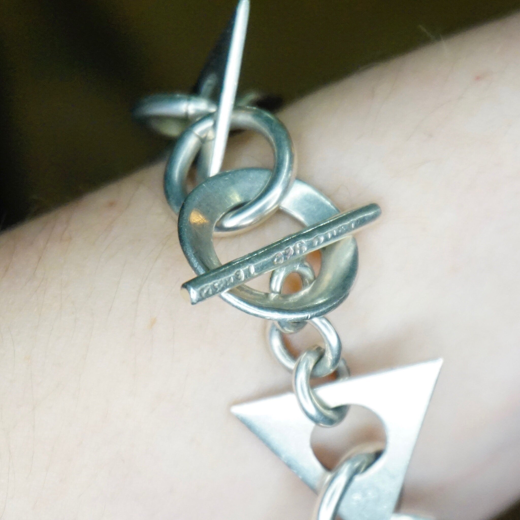 Vintage Taxco 925 sterling silver link bracelet with geometric shapes on a wrist