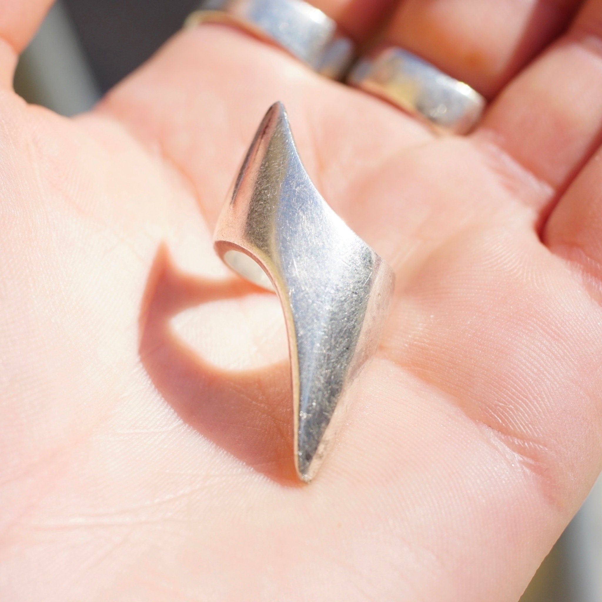 Vintage sterling silver lightning bolt ring on a hand, featuring an elongated pointed design. Solid 925 silver ring from Israel in a petite, long style. Size 5 1/2 US.