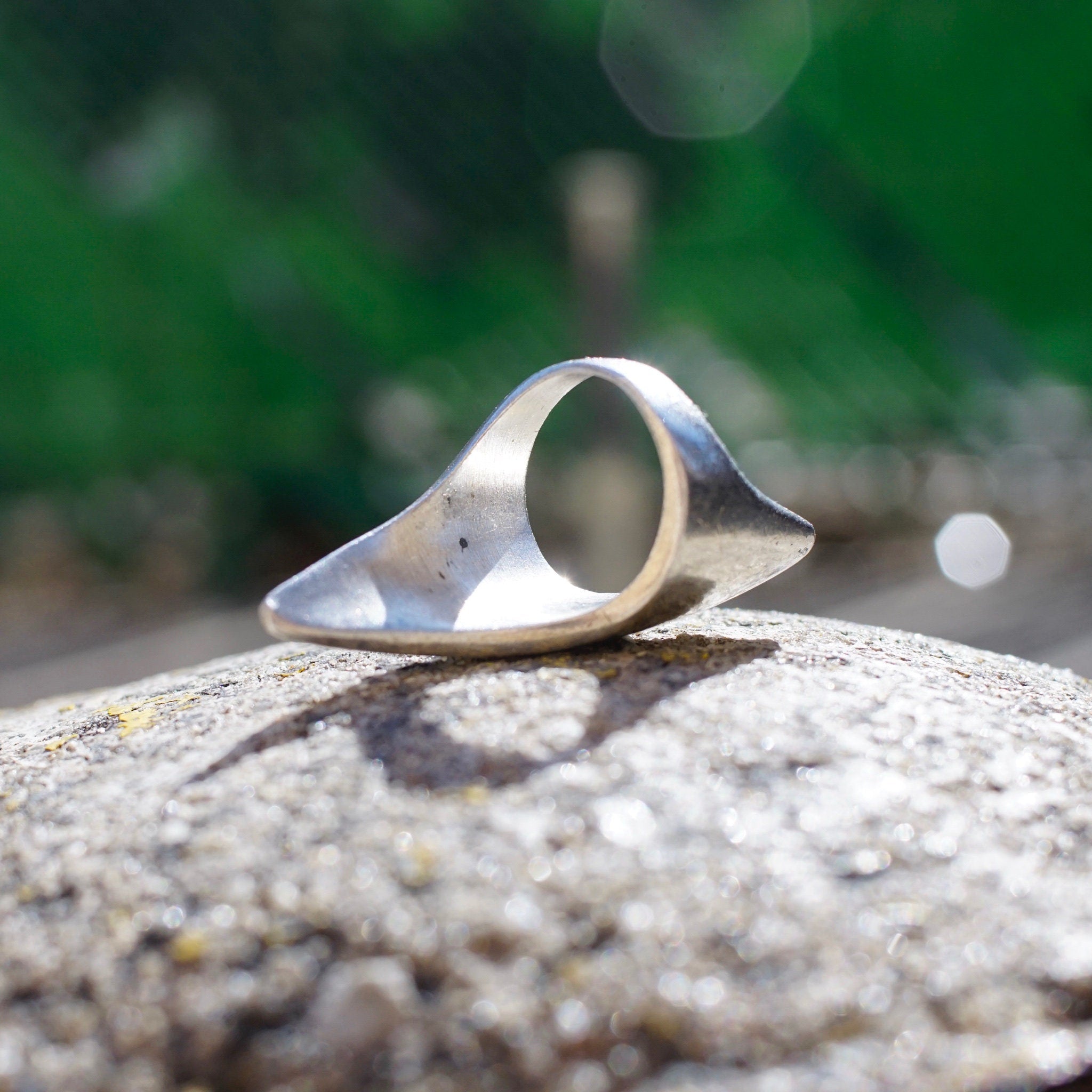 Vintage sterling silver lightning bolt ring on stone surface outdoors