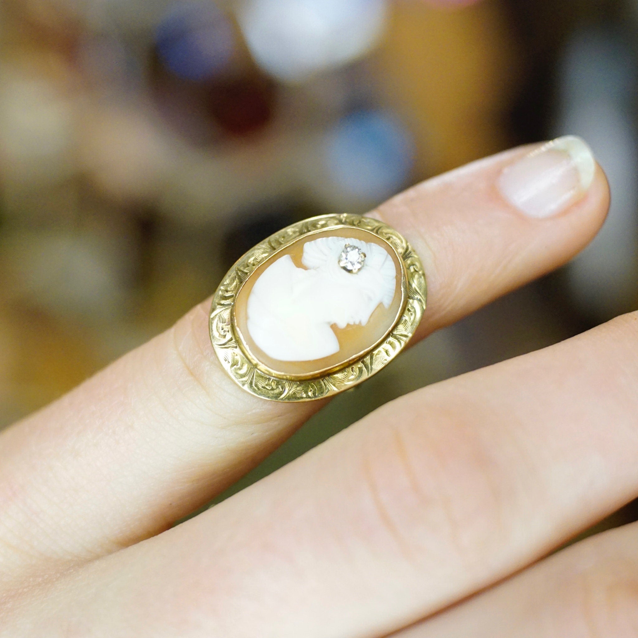 Vintage 14K gold cameo ring with ornate engraved setting and accent diamond, featuring a delicately carved shell cameo on an antique gold band, size 3 3/4 US.