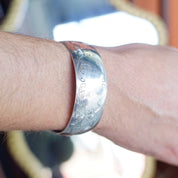 Vintage S. Kirk & Son sterling silver cuff bracelet with etched floral design on wrist, close-up view showing space for monogram engraving.