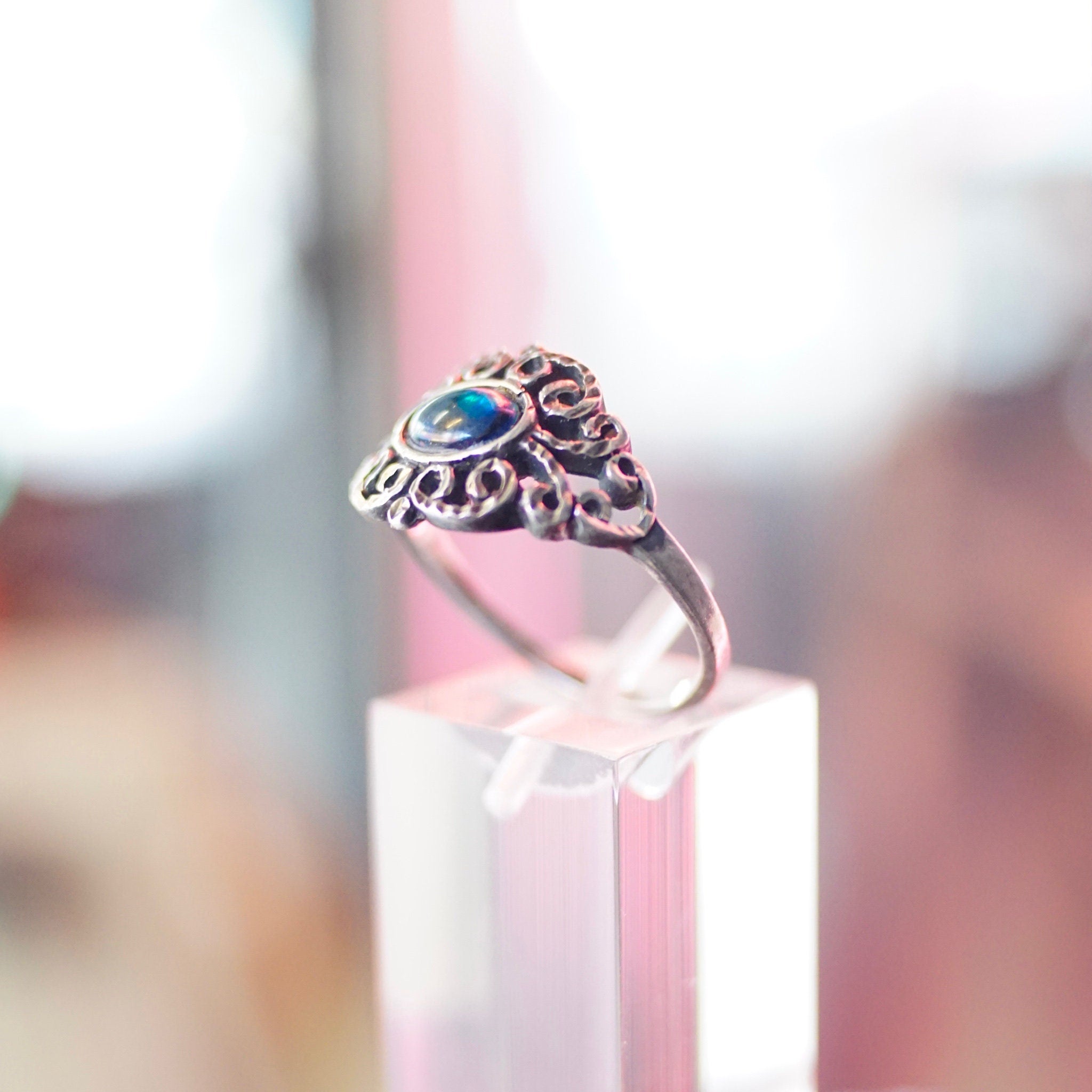 Vintage ornate sterling silver ring with iridescent blue glass stone, featuring a hammered and textured silver band. Size 9 1/4 US.