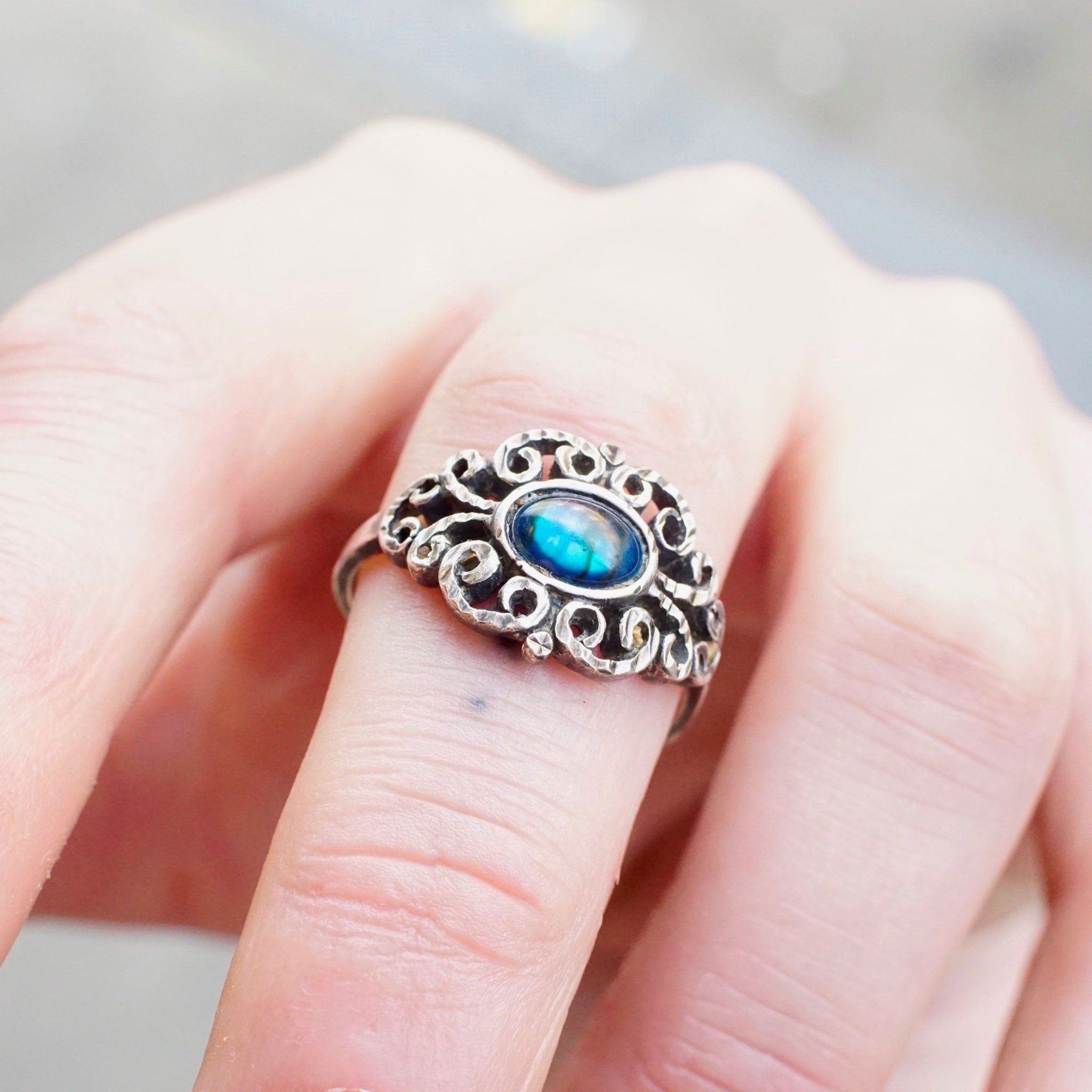 Vintage ornate sterling silver ring with iridescent blue glass stone, featuring a hammered and textured silver band. Size 9 1/4 US.