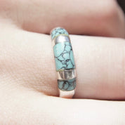 Vintage sterling silver ring with light blue speckled turquoise inlay on a tapered band, shown on a finger. Stackable turquoise and silver ring, size 8 1/2 US.