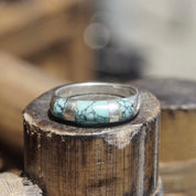 Vintage sterling silver ring with light blue speckled turquoise inlay on a tapered band, stackable ring size 8 1/2 US, displayed on a rustic wooden surface.