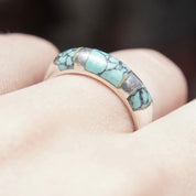 Vintage sterling silver ring with light blue speckled turquoise inlay on tapered band, worn on finger, size 8 1/2 US.