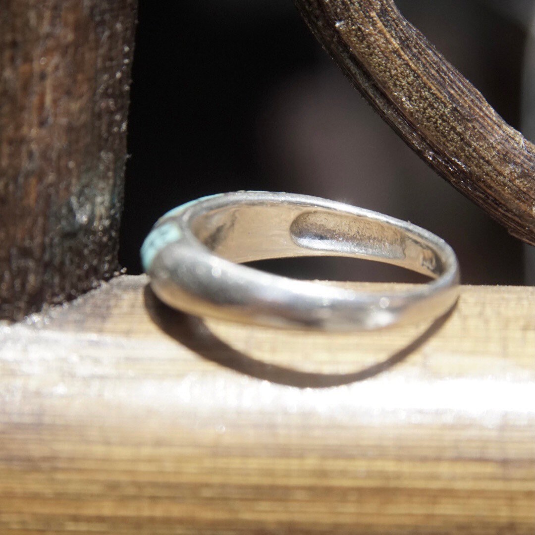 Vintage sterling silver ring with light blue speckled turquoise inlay on a tapered band, stackable ring size 8 1/2 US, on wooden surface