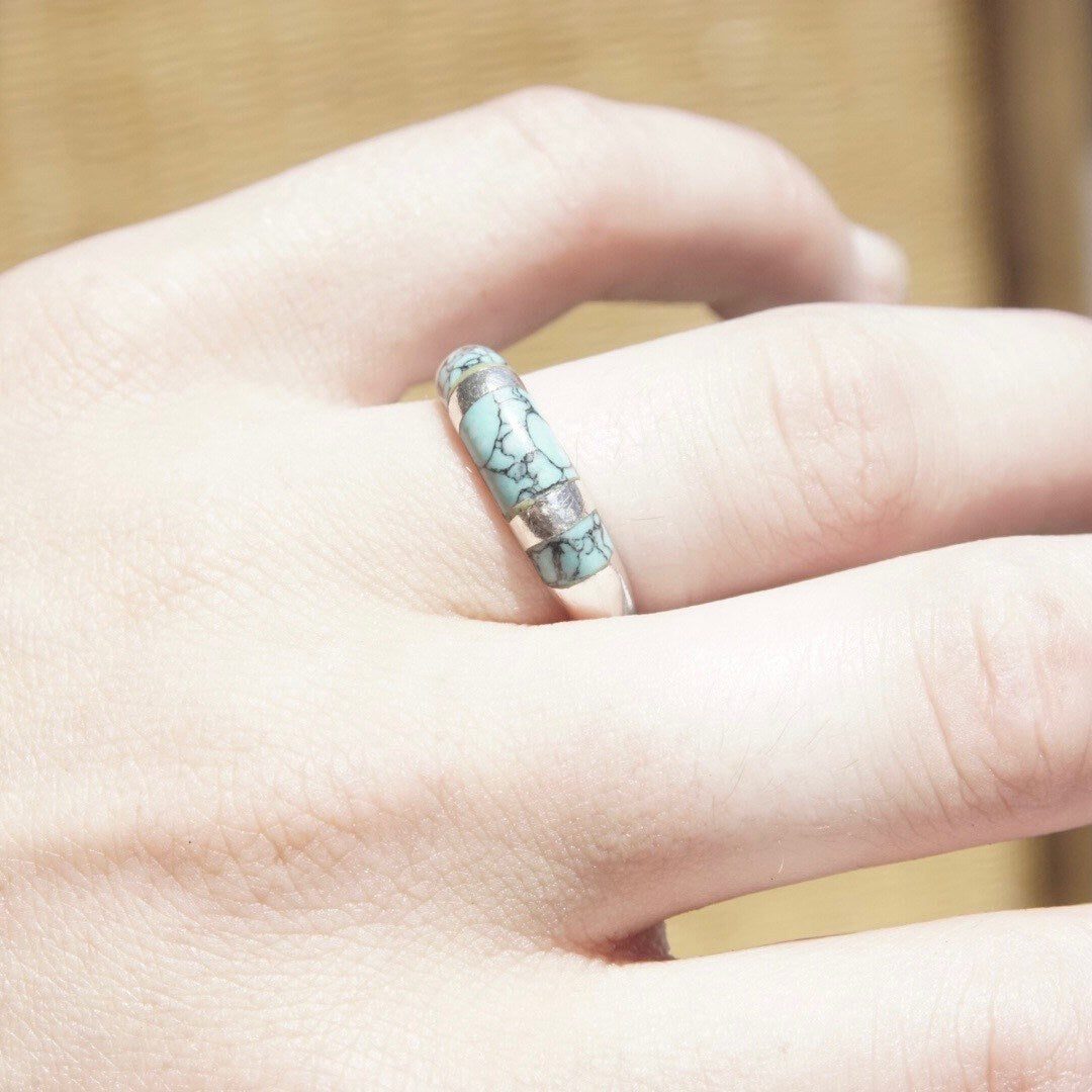 Vintage sterling silver turquoise inlay ring on a hand, featuring a light blue speckled turquoise inlay on a tapered silver band, size 8 1/2 US.