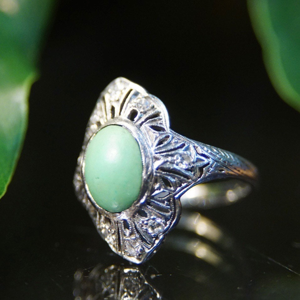 Vintage 18K white gold art deco filigree ring with matte green turquoise center stone and diamond encrusted shield design, size 7 3/4 US.