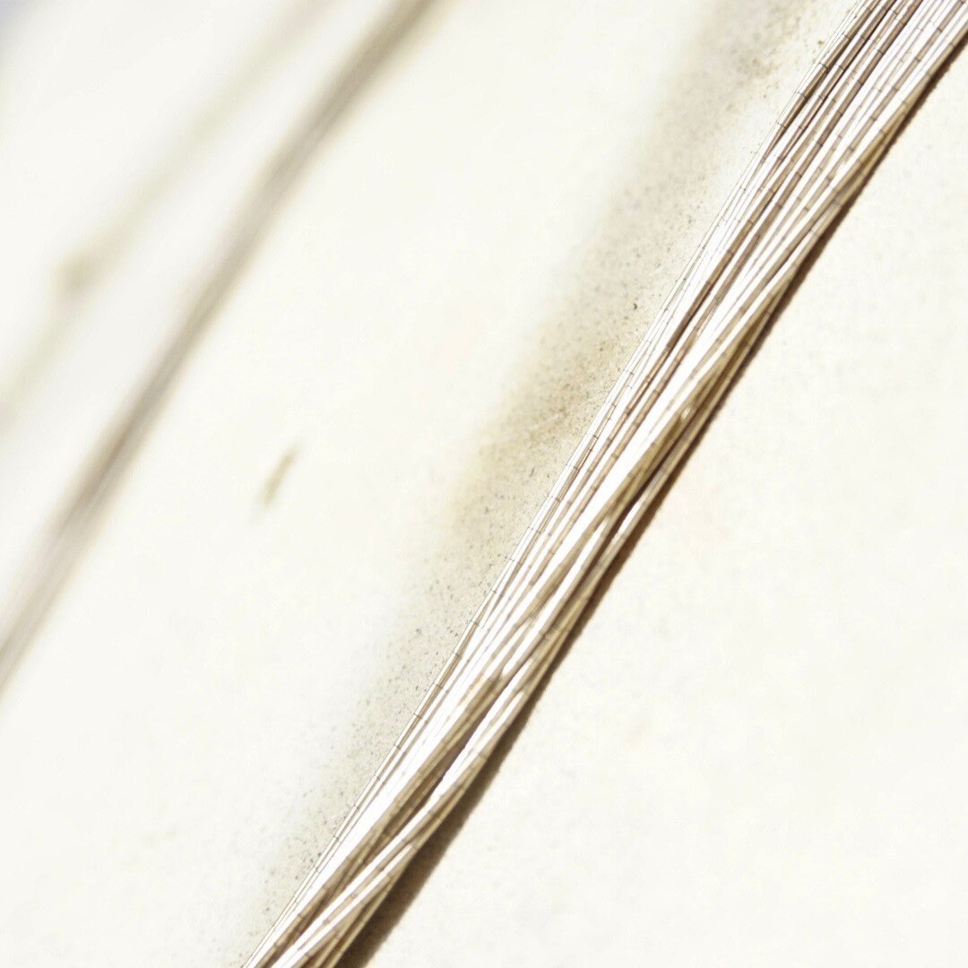 Vintage modernist sterling silver multi-strand liquid silver necklace with coned caps and hook closure, 30 inches long, 925 silver statement necklace closeup on white fabric