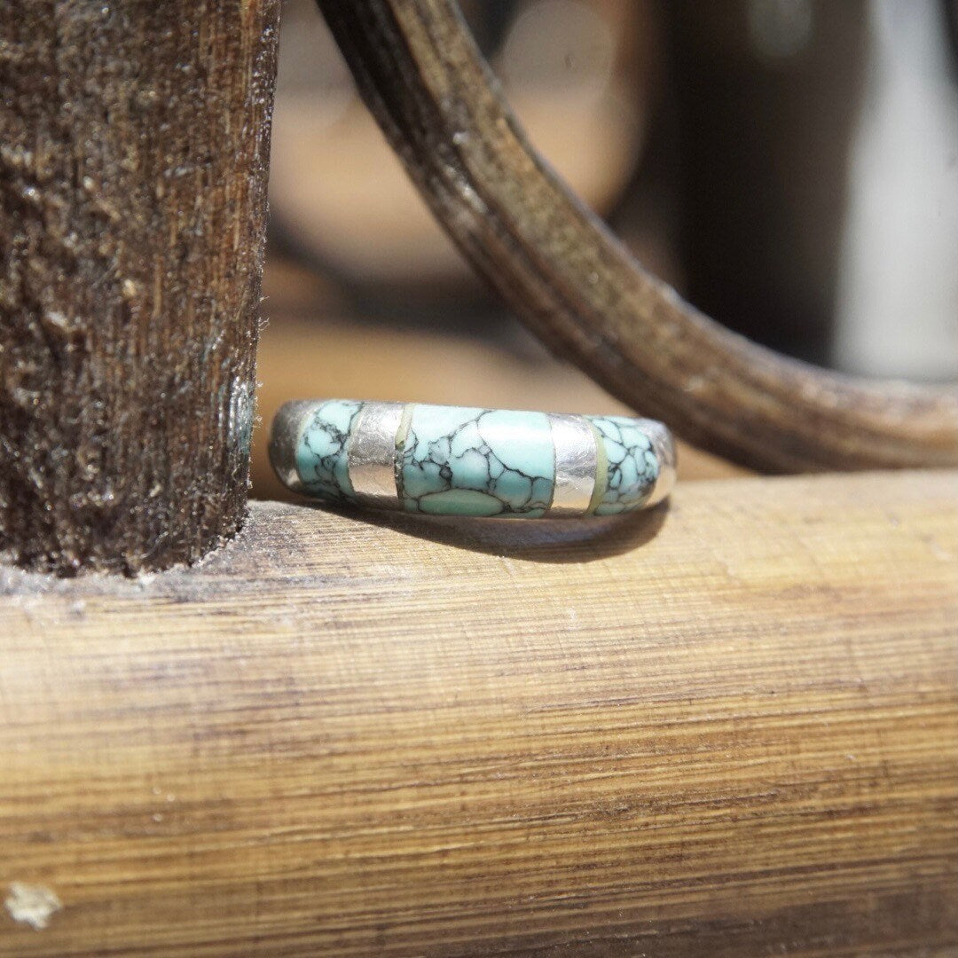 Vintage sterling silver turquoise inlay ring with tapered band, featuring light blue speckled turquoise stone, stackable style, size 8 1/2 US, resting on weathered wood surface.