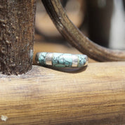 Vintage sterling silver turquoise inlay ring with tapered band, featuring light blue speckled turquoise stone, stackable style, size 8 1/2 US, resting on weathered wood surface.