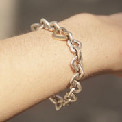 18K gold and sterling silver heart link bracelet from Tiffany & Co., circa 2000. Two-tone curb link design, measuring 7 1/2 inches long. Vintage Tiffany jewelry.