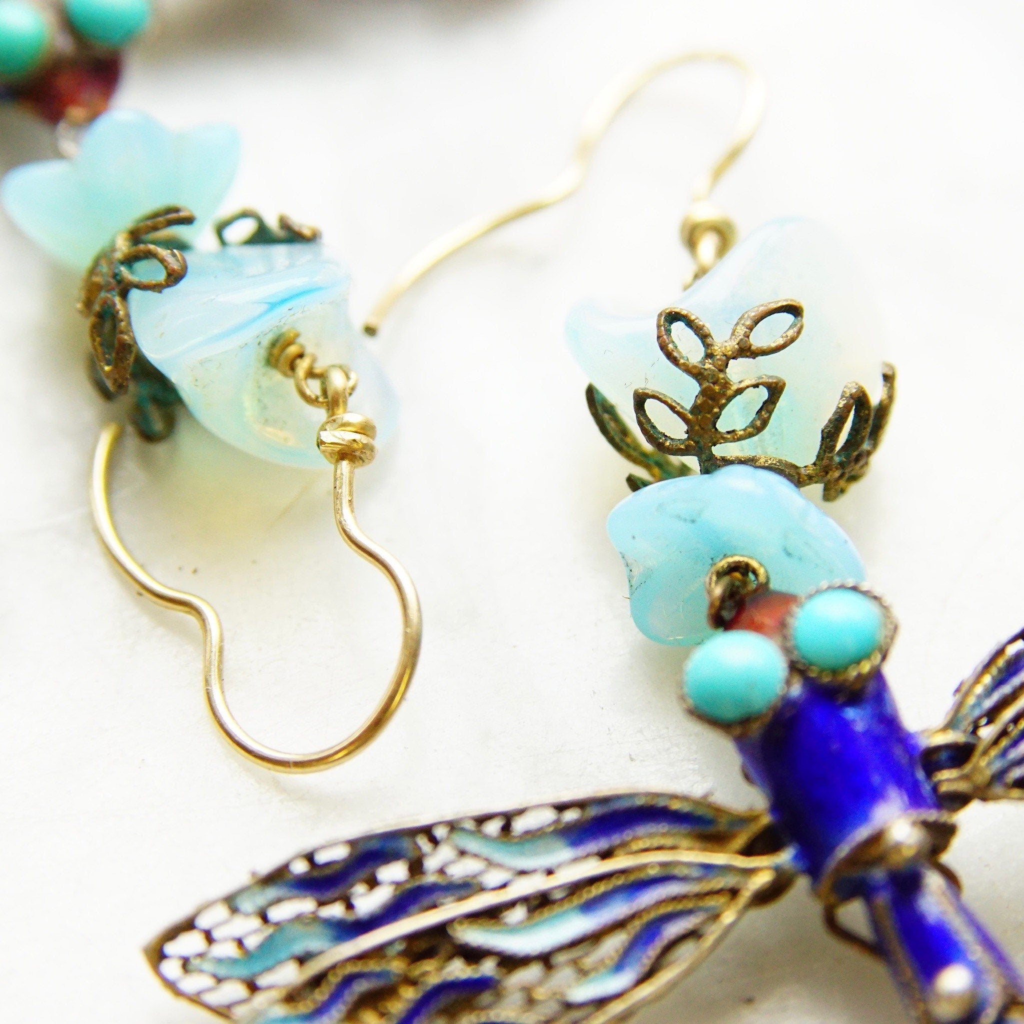 Vintage Chinese gilt sterling silver filigree articulated blue enamel dragonfly dangle earrings with opalescent blue glass stones, measuring 3 inches long.