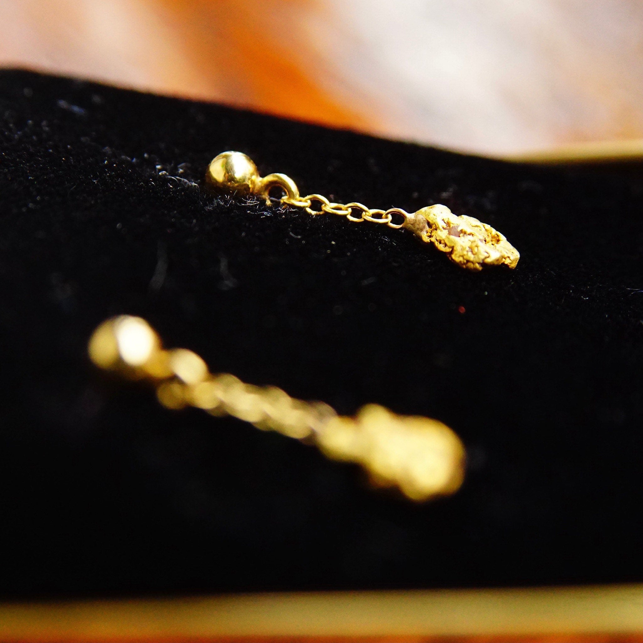Vintage 14K yellow gold nugget dangle earrings with natural gold nuggets, petite gold post tassel design, and 14K gold push backs, measuring 5/8 inches long.