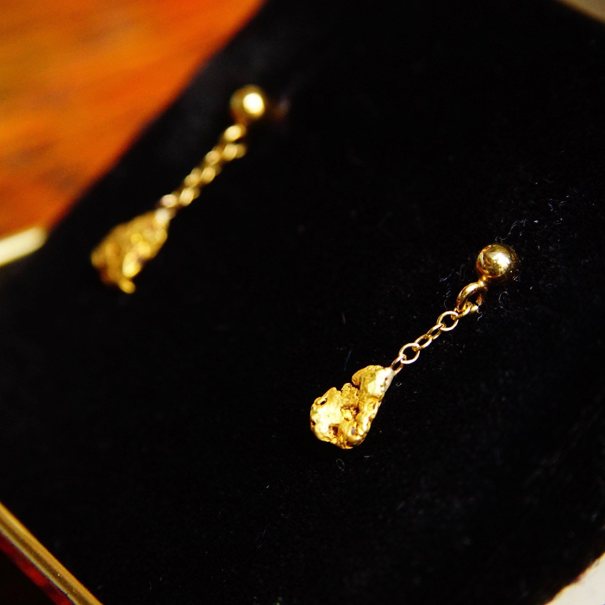 Vintage 14K yellow gold nugget dangle earrings with natural gold nuggets on delicate gold chain, showcasing rough organic texture in a classic tassel style secured with 14K gold push backs, measuring 5/8 inch in length.