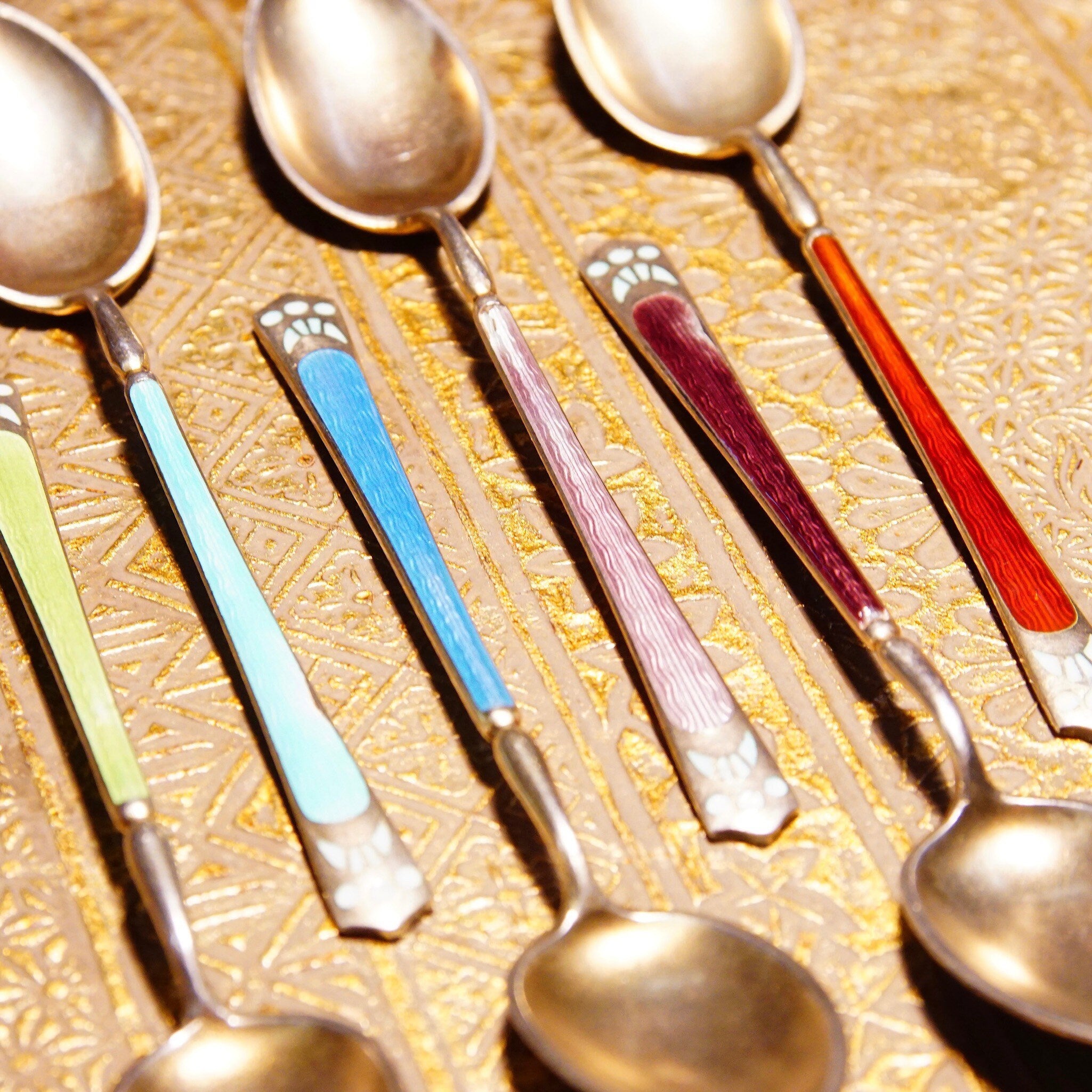 Antique set of 6 colorful Art Deco sterling silver guilloche enamel demitasse spoons with Scandinavian 930S hallmarks, arranged on textured gold background