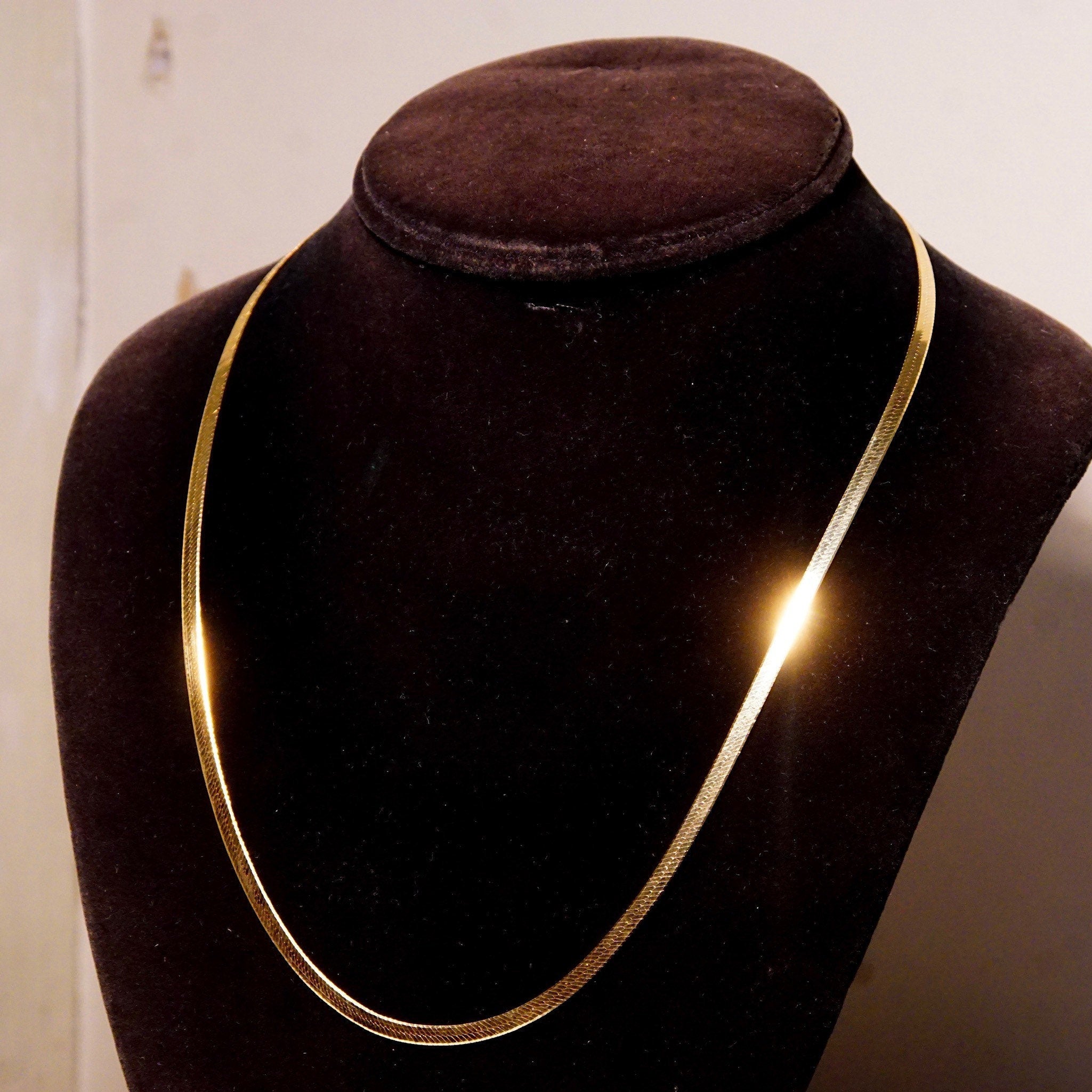 Vintage 14K yellow gold herringbone chain necklace on display, Italian-made unisex minimalist flat 3mm herringbone chain, 20 inches long.