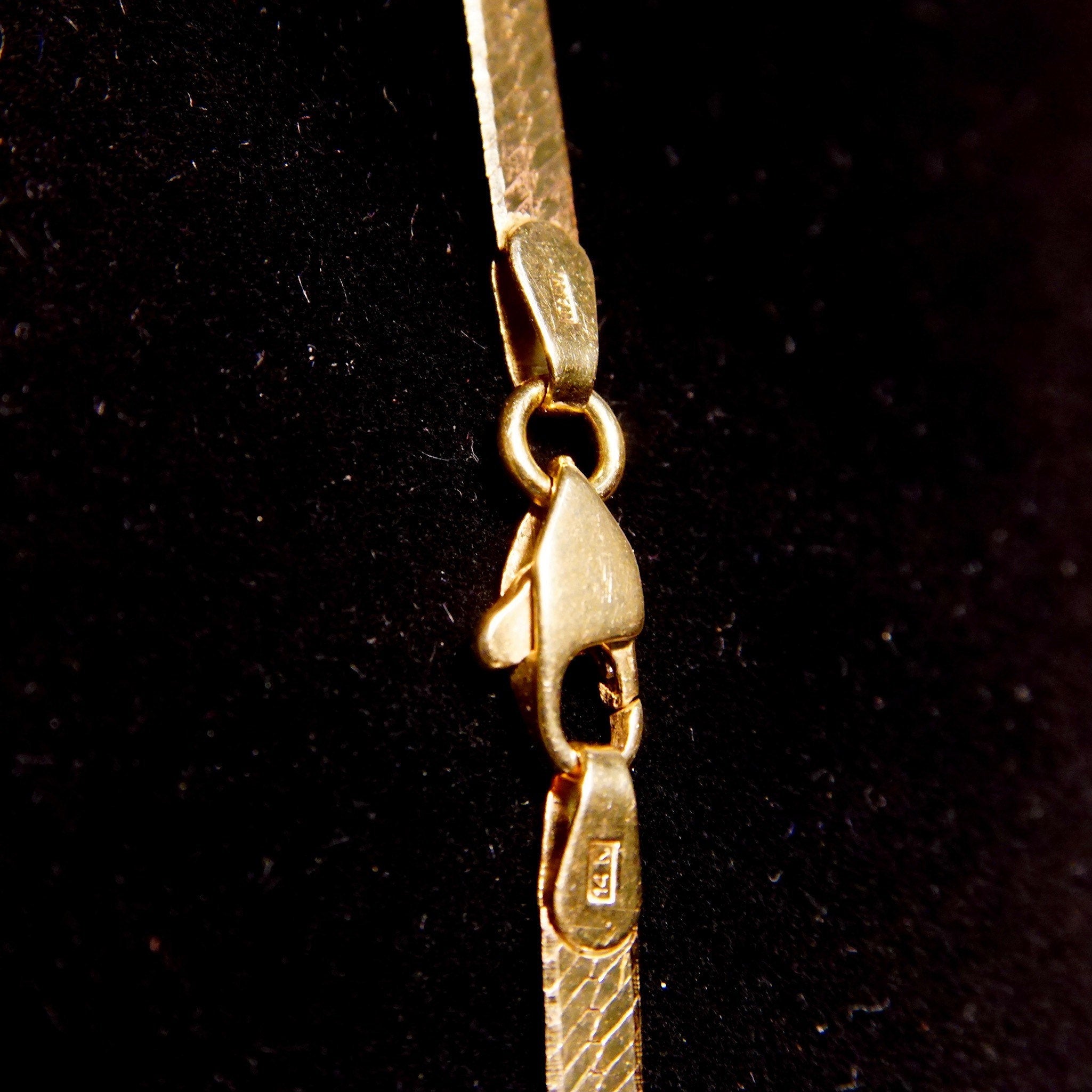 Vintage 14K yellow gold herringbone chain necklace, 3mm wide flat links, 20 inches long, minimalist unisex design, close-up view on black background.