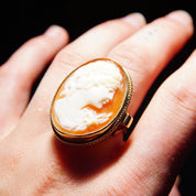 10K yellow gold Victorian cameo ring with intricate carved shell cameo portrait on ornate scroll gold setting, displayed on hand, size 7 1/2 US.