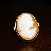 Antique 10K yellow gold ring featuring a large, intricately carved shell cameo portrait in a decorative scroll setting, size 7.5 US.