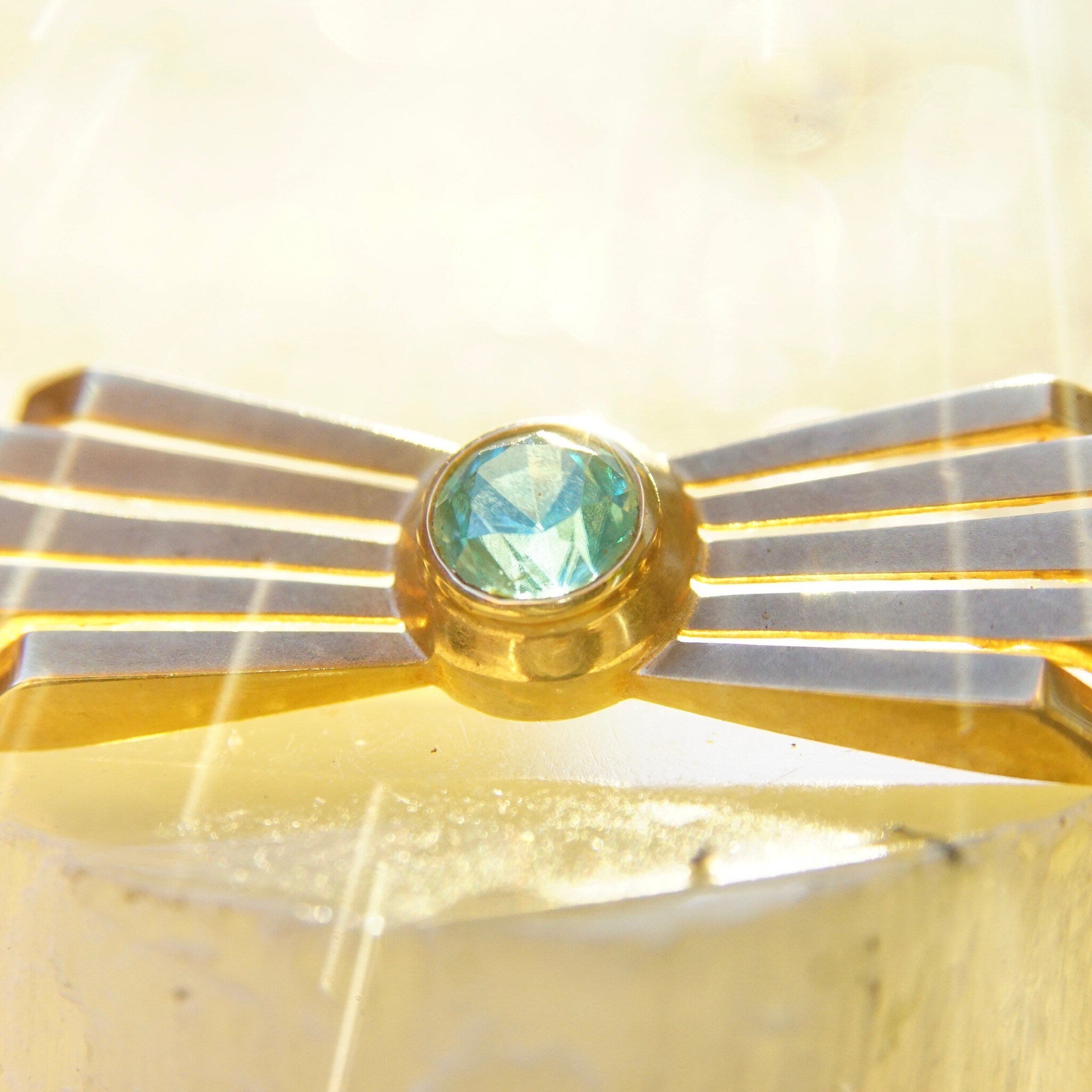 Vintage 14K rose gold Art Deco bar pin brooch featuring a brilliant blue aquamarine gemstone in a radiant golden ray setting, measuring 2 inches long, stamped 585.