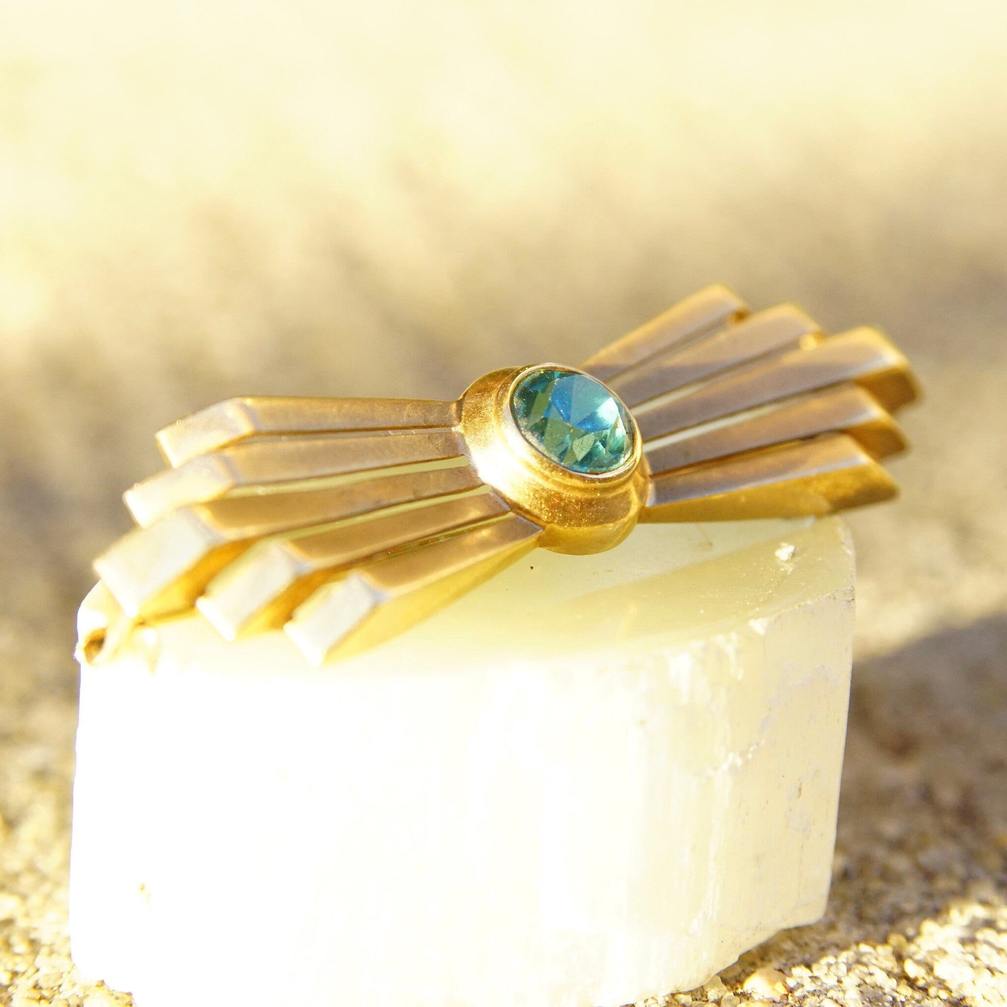 Vintage 14K rose gold Art Deco bar pin brooch featuring a brilliant blue aquamarine gemstone in a golden ray deco setting, measuring 2 inches long.