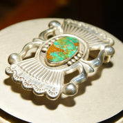 Vintage Native American sterling silver turquoise belt buckle featuring intricate sandcast design by renowned Zuni artisan Art Acoya, measuring 2 7/8 inches wide, showcasing vibrant blue-green turquoise stone at center.