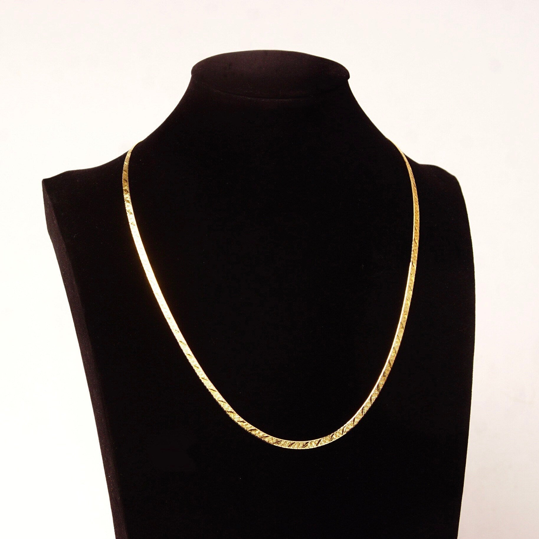 14K yellow gold Italian herringbone chain necklace with diamond-cut texture, reversible design, and 3.5mm width, displayed on a black jewelry bust against a white background.