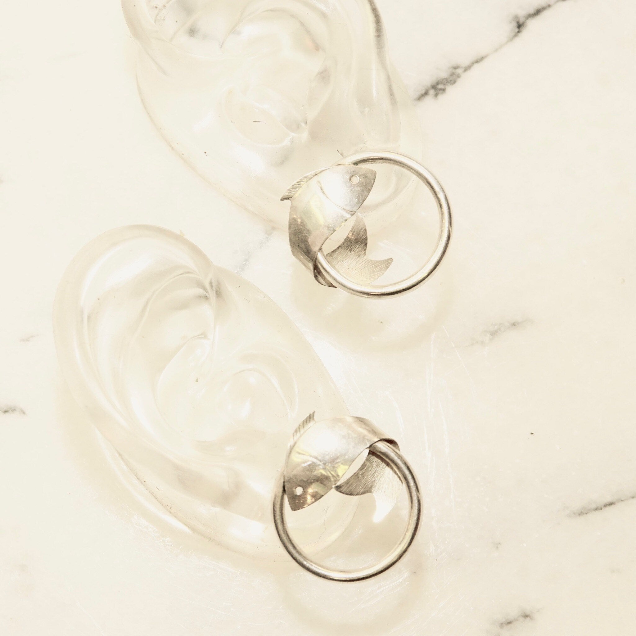 Vintage sterling silver hoop earrings with wrap around fish embellishments, lightweight small 925 silver tube hoops measuring 1 inch in diameter.