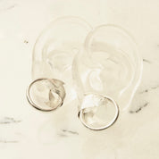 Vintage sterling silver fish hoop stud earrings with lightweight tube hoops and wrap around fish embellishments, small 925 silver hoops measuring 1 inch in diameter on marble background