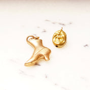 Vintage 10K gold plated charms including a rose gold Victorian boot charm and a yellow gold screaming head charm on a white marble background.