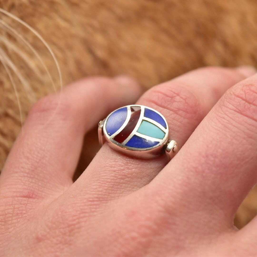 Vintage sterling silver multi-stone inlay flip ring with lapis lazuli, turquoise and carnelian, worn on a finger. Colorful scarab beetle fidget ring, size 8 US.