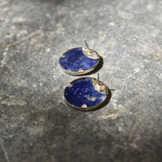 Vintage modernist sterling silver lapis lazuli yin-yang stud earrings on textured gray stone surface
