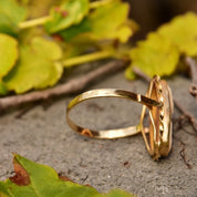 Vintage 10K gold cameo ring with classic relief shell carving in elongated oval shape, set in yellow gold ribbon setting, size 10 US, displayed on natural leafy background