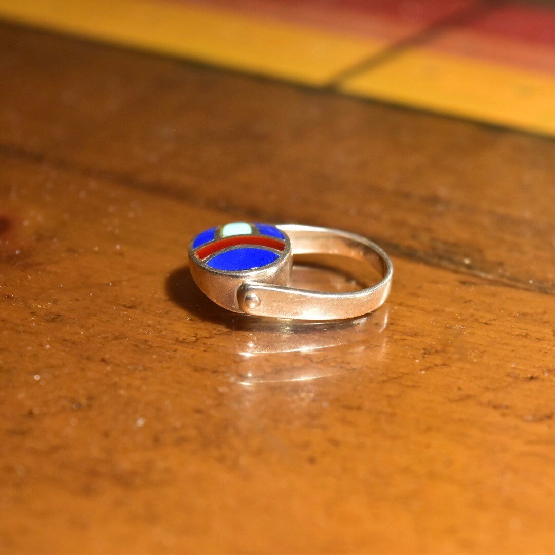 Vintage sterling silver multi-stone inlay flip ring with lapis lazuli, turquoise and carnelian stones, colorful fidget ring reminiscent of a scarab beetle, size 8 US, on wooden surface